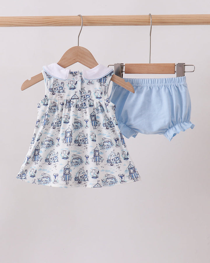 Baby dress with blue and white pattern and matching bloomers on hangers against a light background