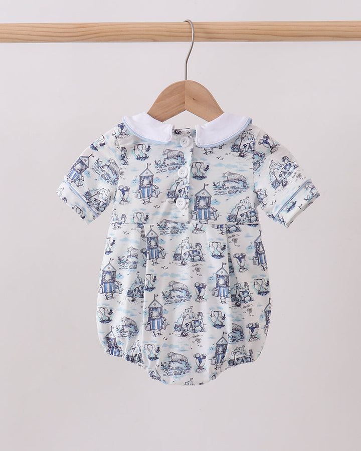 Baby romper with blue and white pattern on a wooden hanger against a light background
