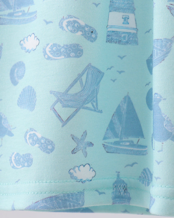 Fabric with nautical pattern including lighthouse, sailboat, and beach chair on a light blue background
