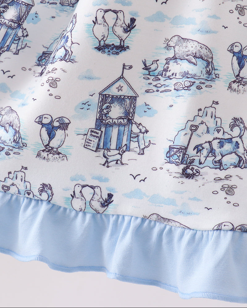 Dress with beach-themed design featuring penguins, polar bears, and sandcastles on a blue and white background.