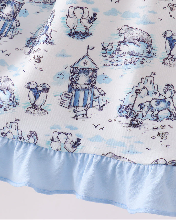 Dress with beach-themed design featuring penguins, polar bears, and sandcastles on a blue and white background.