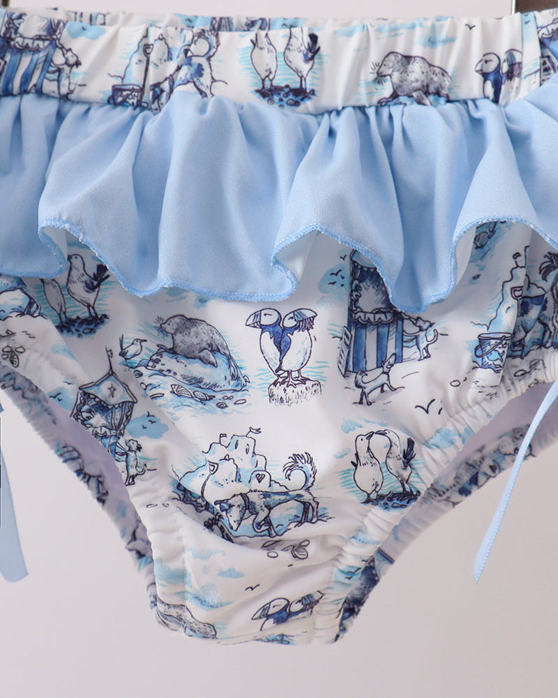 Swim bottoms with blue ruffle and animal print on a white background