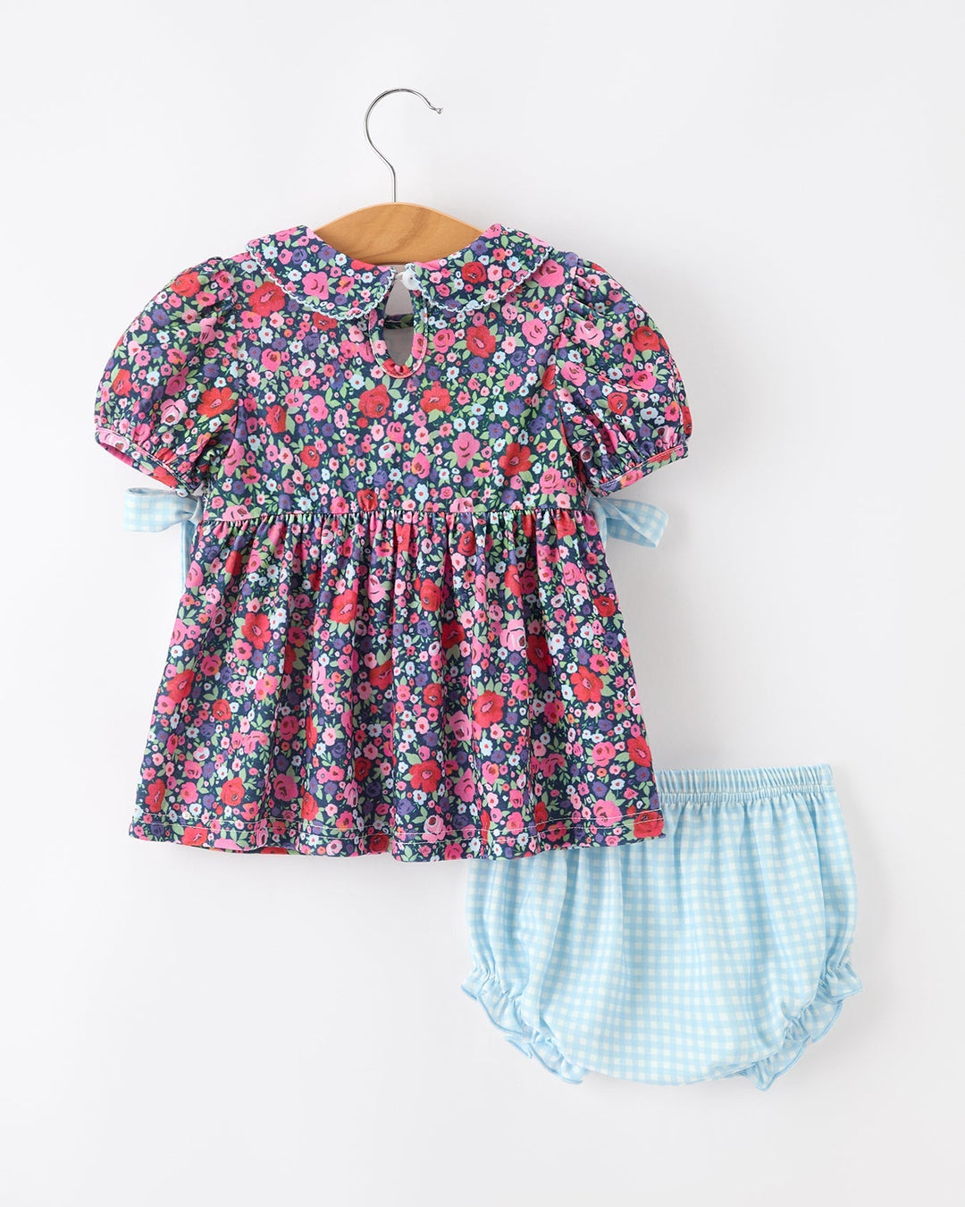 Girls navy floral smocked dress with puff sleeves and light blue gingham bloomer