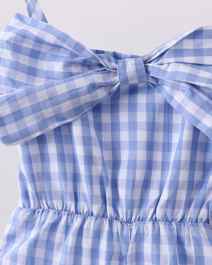 Blue and white checkered jumpsuit with a bow detail on a white background