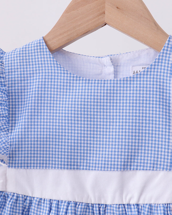 Blue and white checkered dress on a wooden hanger with a white background