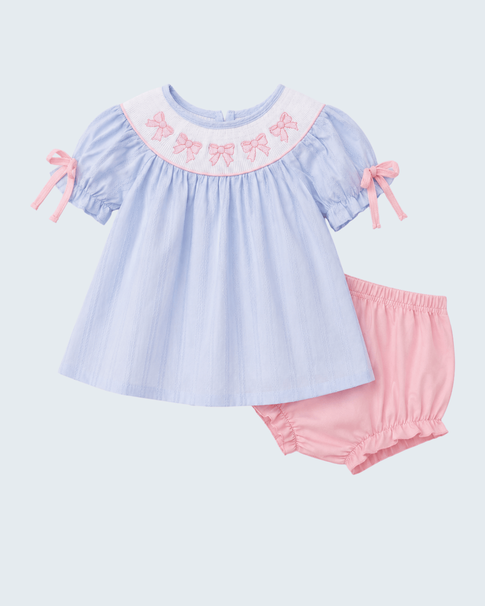 Light blue top with pink trim and matching pink shorts on a light gray background