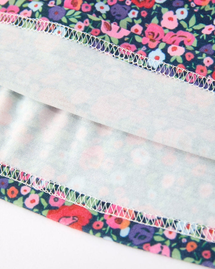 Floral dress hem with decorative multicolor stitch trim