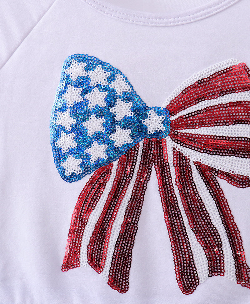 Close-up of a dress with a large bow design featuring American flag colors and patterns.