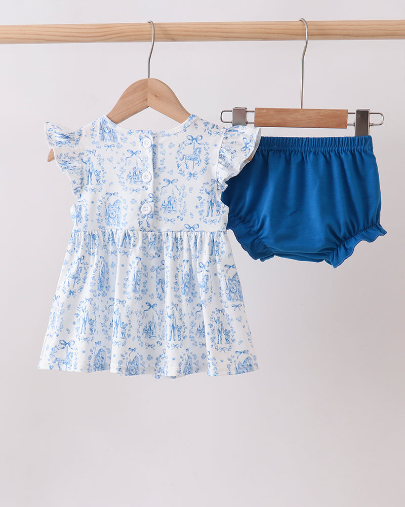 White dress with blue floral pattern and blue bloomers on hangers against a white background