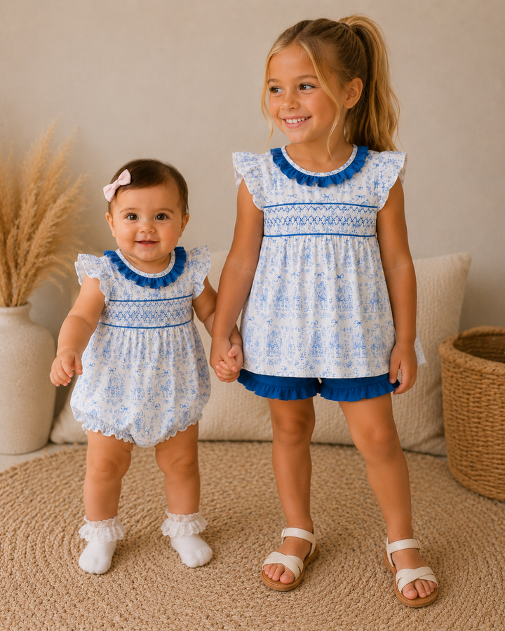 Baby girl is holding hand with older sister. Standing on round rug.