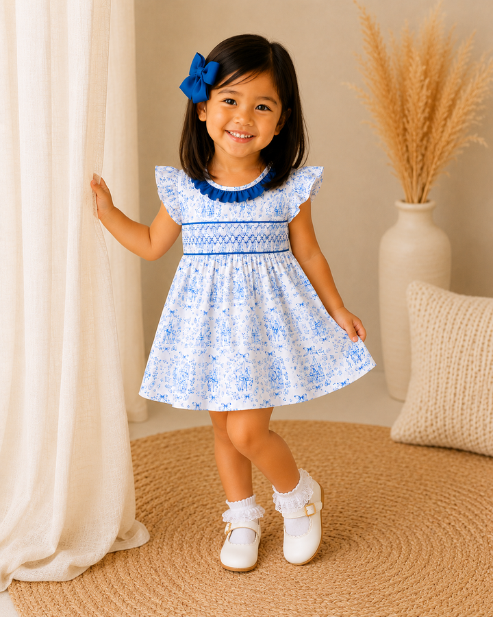 Young girl in a blue floral dress standing in a room with beige curtains and decor.