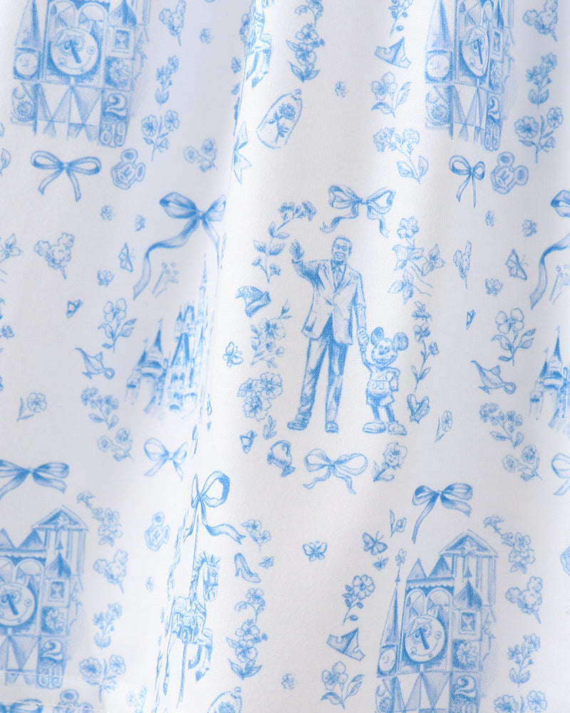 White fabric with blue vintage-style print featuring figures and decorative elements.