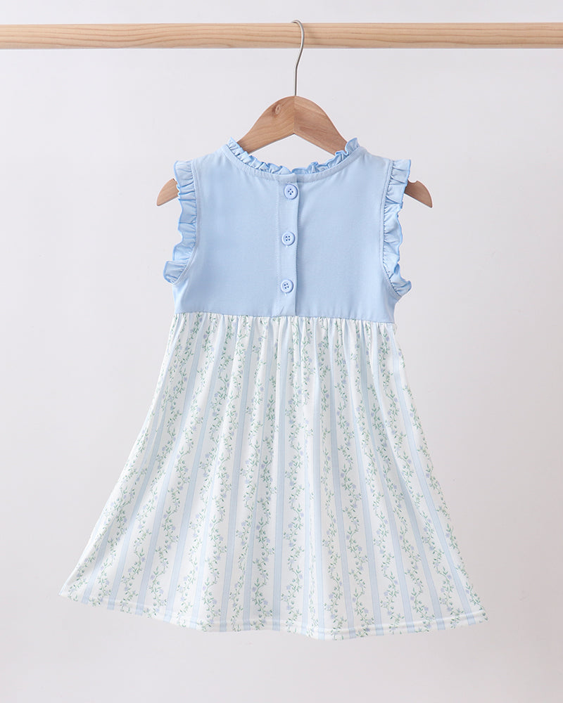 Light blue dress with floral skirt on a hanger against a light background