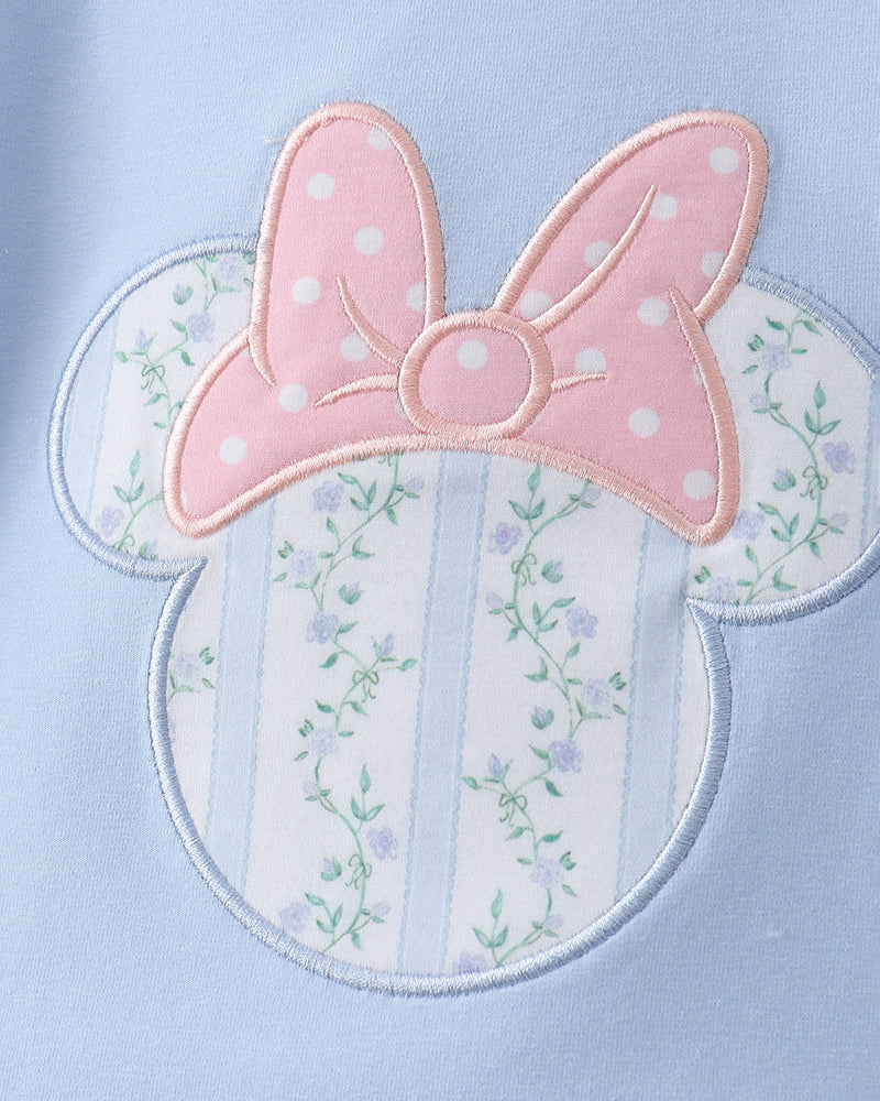 Embroidered design of a bow with floral details on a light blue background