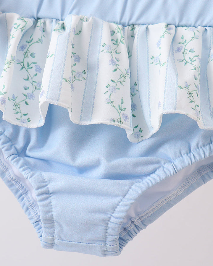 Light blue baby bloomers with floral patterned diaper cover on a white background