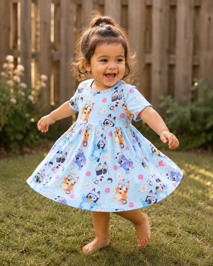 Child wearing a light blue dress with cartoon character print outdoors