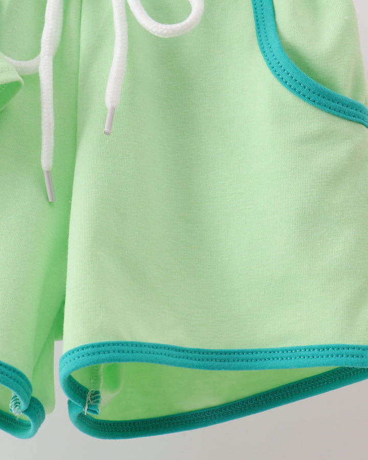 Green shorts with white drawstring on a light gray background