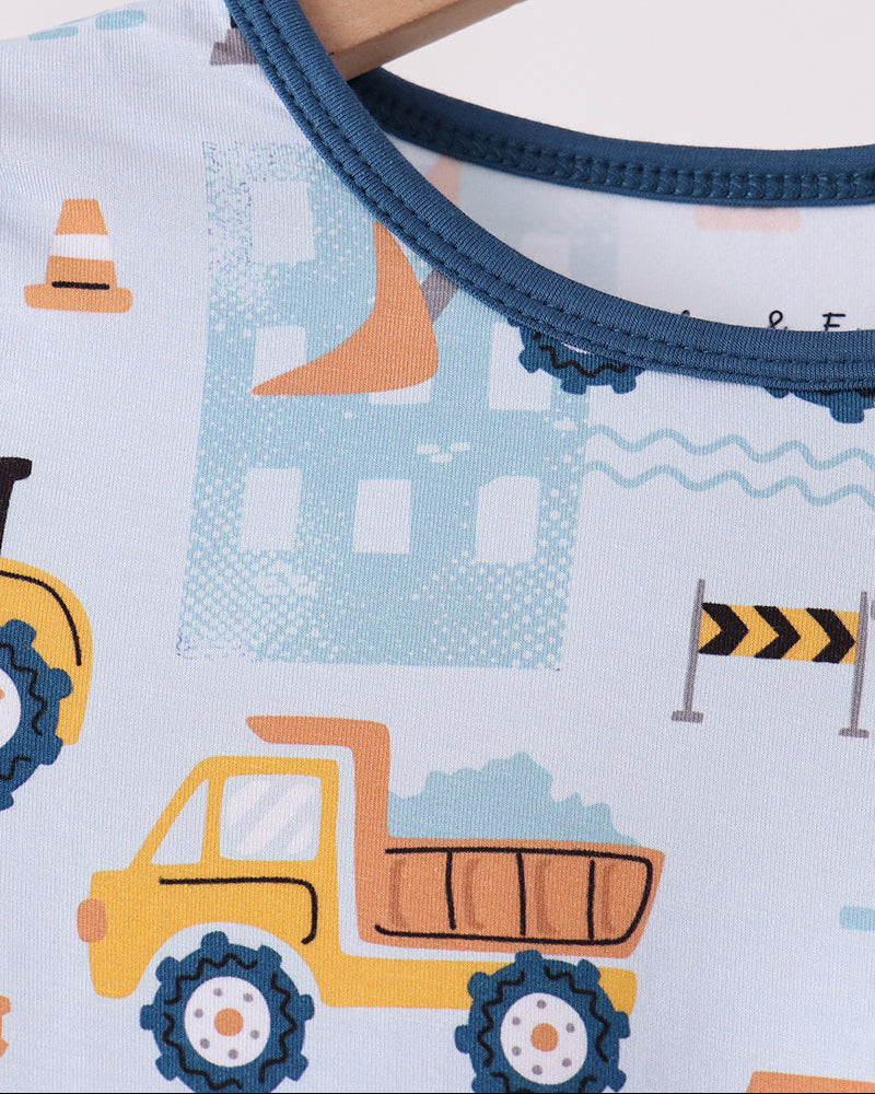Long-sleeve pajama top neckline with dark blue binding and construction truck graphics