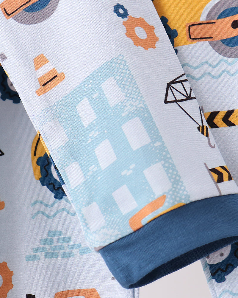 Pajama fabric close-up with construction print, dark blue cuff trim, and soft knit texture