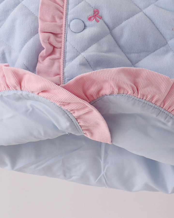 Light blue quilted jacket hem with pink ruffle trim and scalloped edge