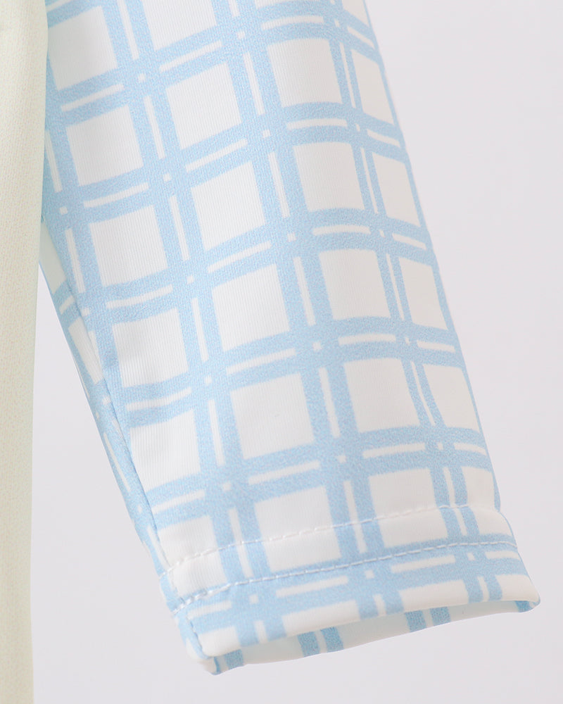 Folded fabric with blue and white checkered pattern on a light gray background