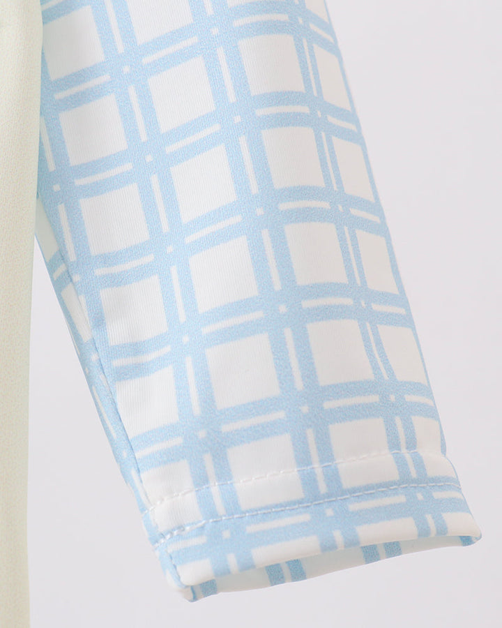 Folded fabric with blue and white checkered pattern on a light gray background