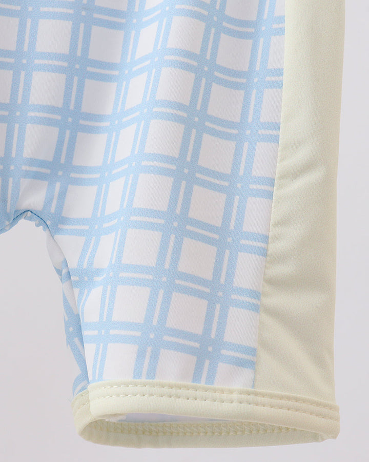 Close-up of a swimsuit with blue plaid pattern on a light gray background