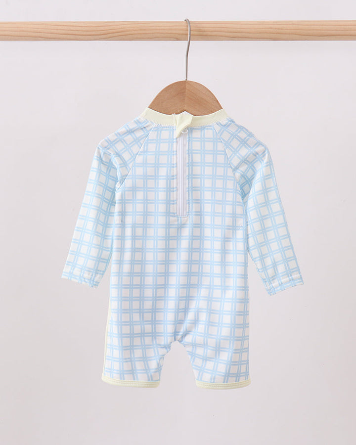 Blue checkered swimsuit on a wooden hanger against a light gray background