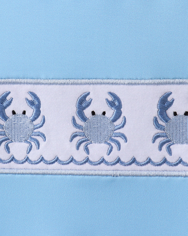 Embroidered crab pattern on a light blue background