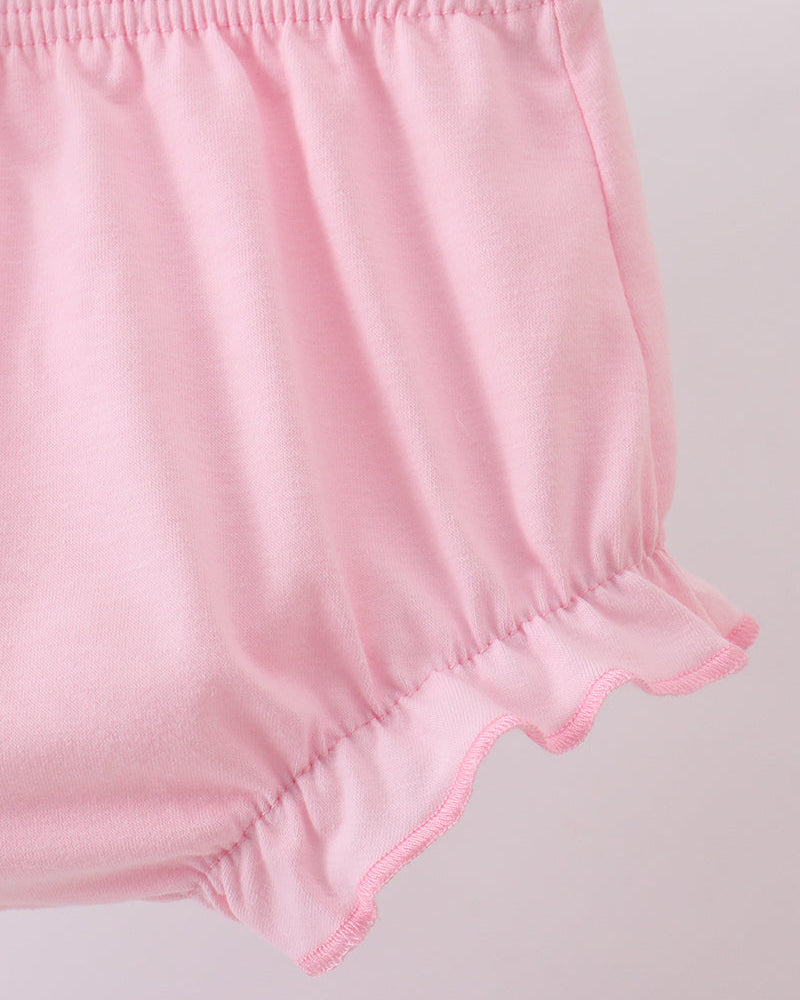 Pink baby bloomers on a light gray background