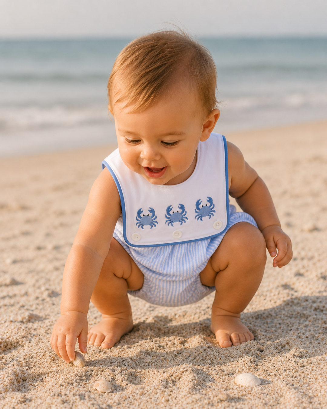 Baby boy playing in the sand on the beach