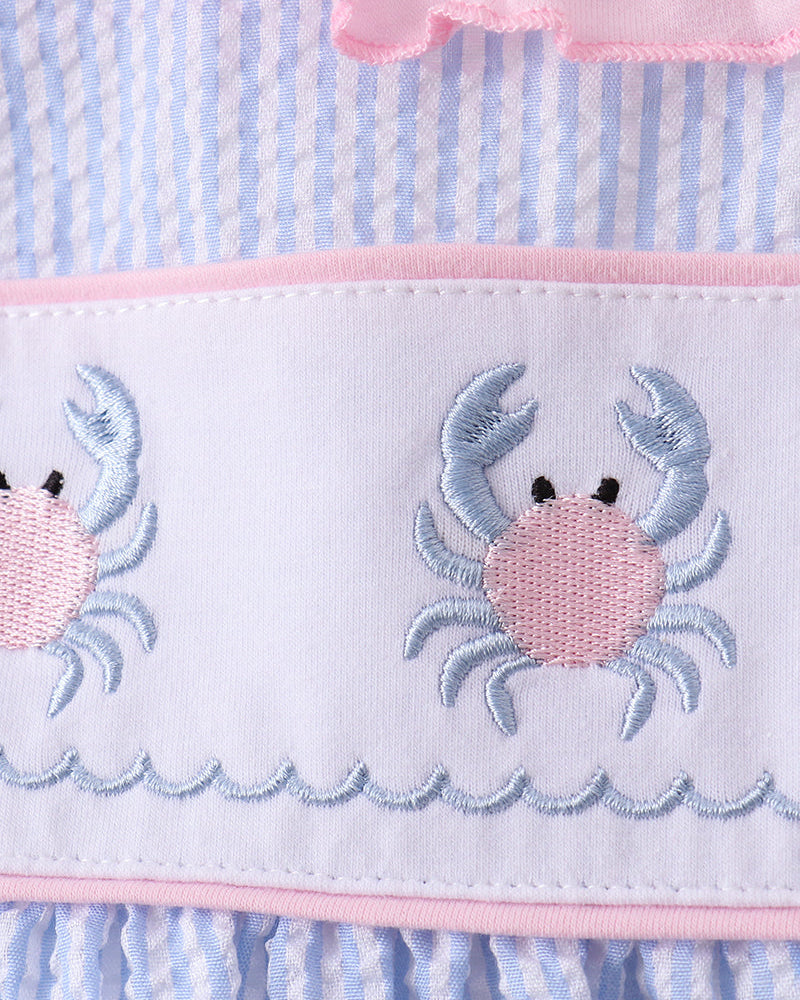 Outfit with crab design on a blue and pink striped background