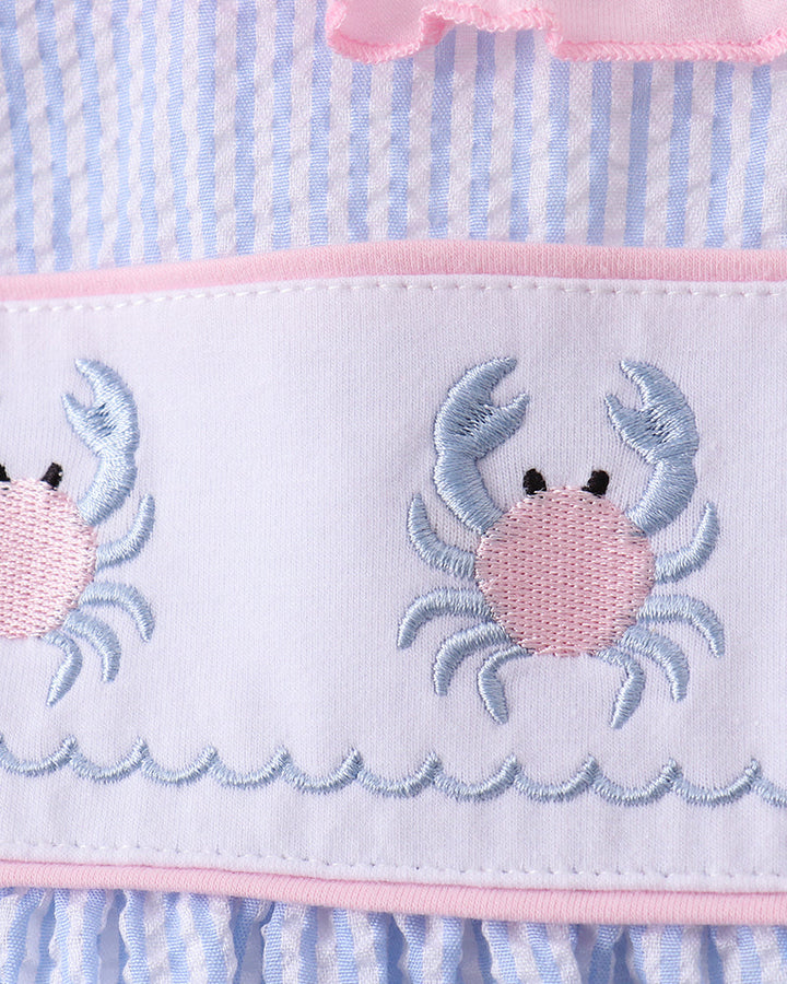 Outfit with crab design on a blue and pink striped background
