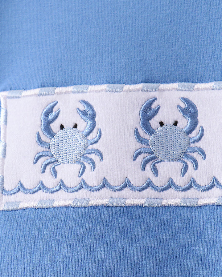 Blue fabric with embroidered crabs and wavy line design