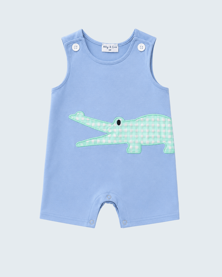 A light blue sleeveless baby romper with a green and white gingham crocodile applique on the front, shown flat against a light gray background.