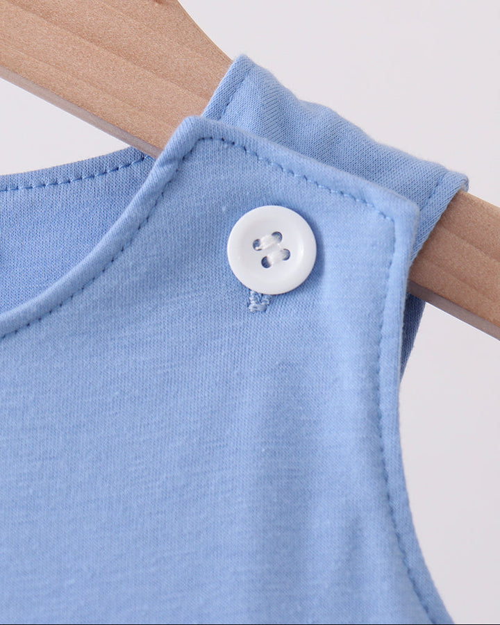 Light blue jon jon with round white button detail at shoulder seam