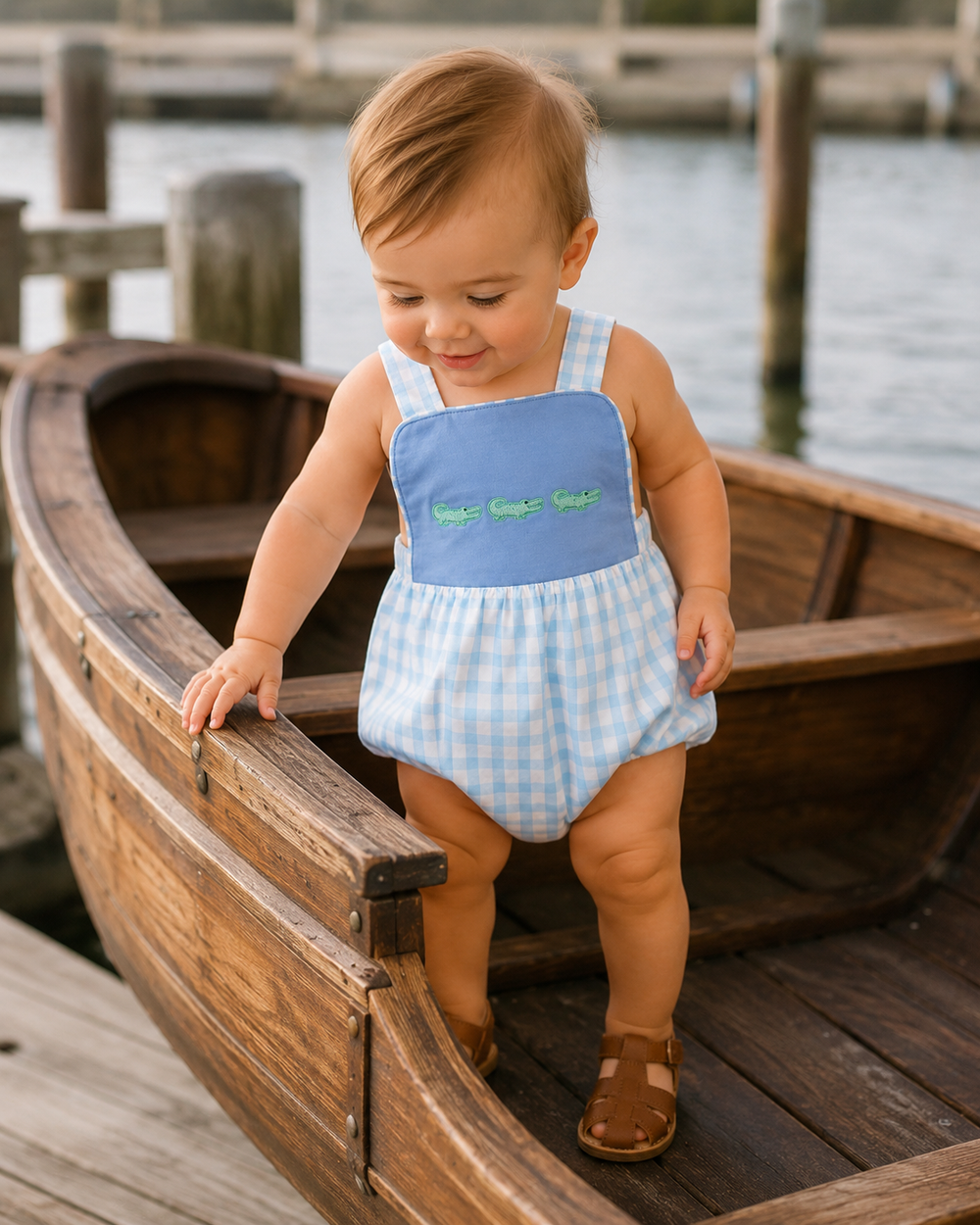 Light blue check bubble romper with green crocodile embroidery on a toddler