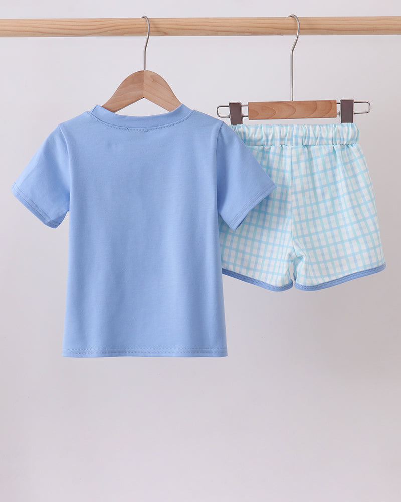 Light blue T-shirt and checkered shorts set on hangers