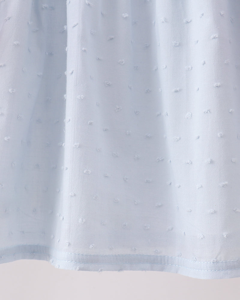 Light blue Swiss dot fabric with gathered ruffle hem on a dress
