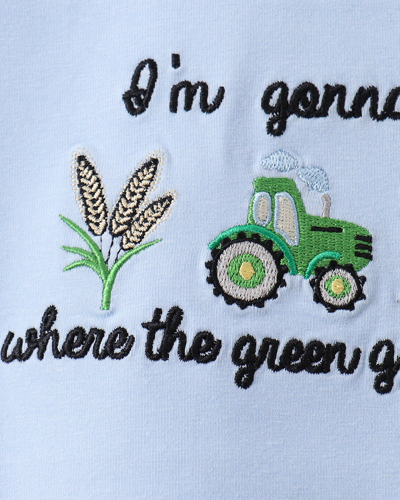 Embroidered design with a tractor, wheat, and text on a light blue background