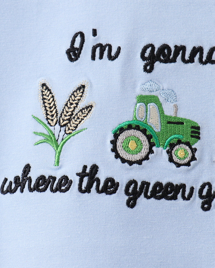 Embroidered design with a tractor, wheat, and text on a light blue background