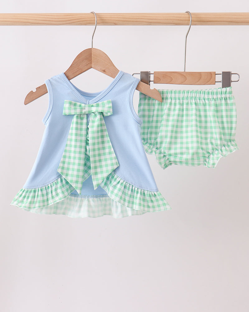 Baby outfit with light blue top and green checkered shorts on a hanger against a white background