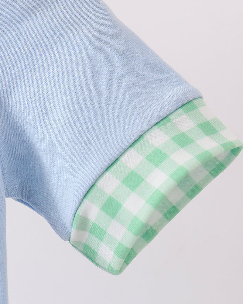 Light blue fabric with a green checkered border on a white background