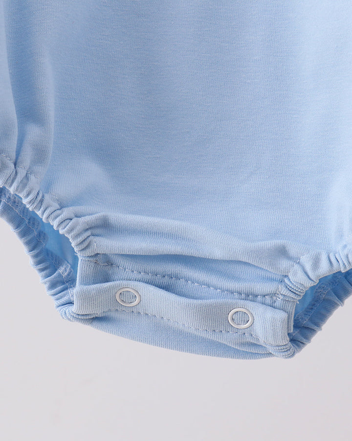 Close-up of a blue baby romper with a plain background
