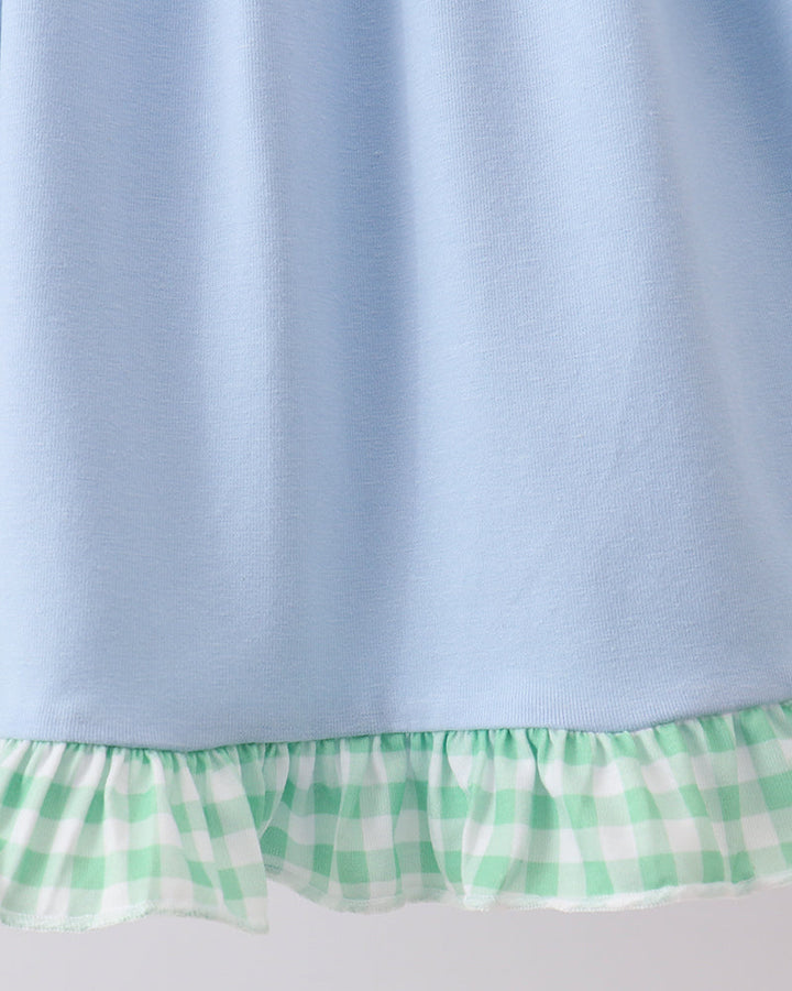 Light blue fabric with a green and white checkered trim on a gray background