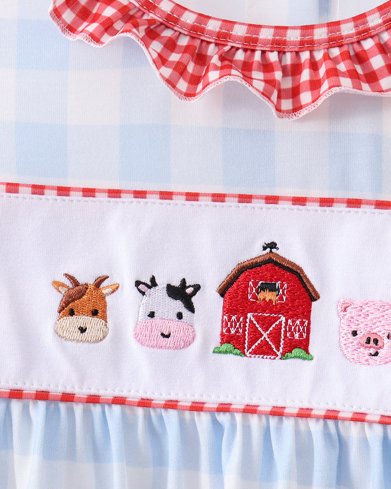White gingham yoke with animal embroidery and red trim on ruffle blouse