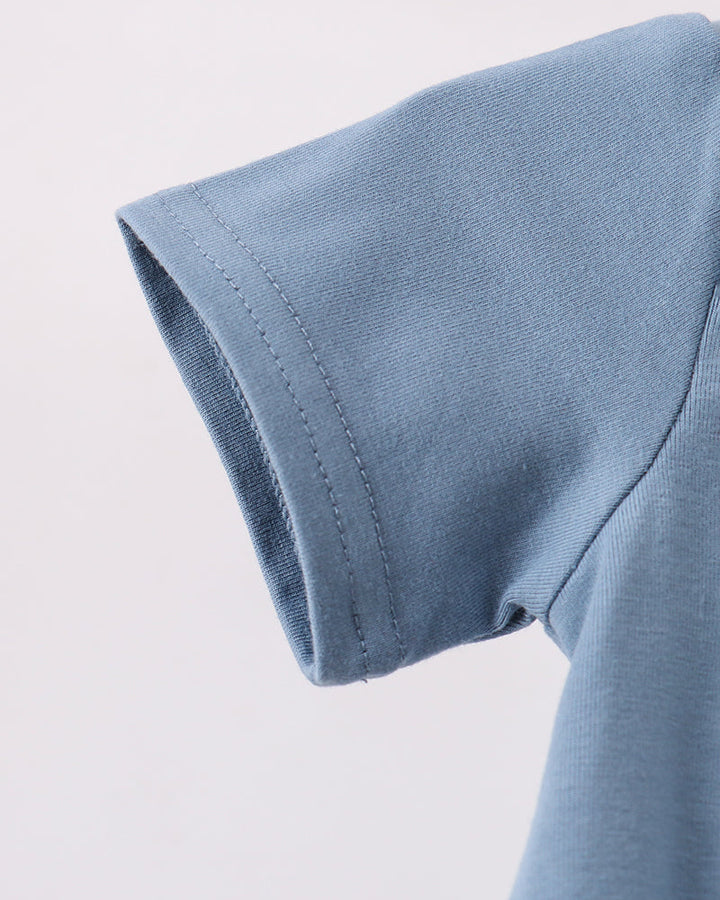 Close-up of a light blue short-sleeve t-shirt showing the sleeve cuff and shoulder seam against a plain light background.