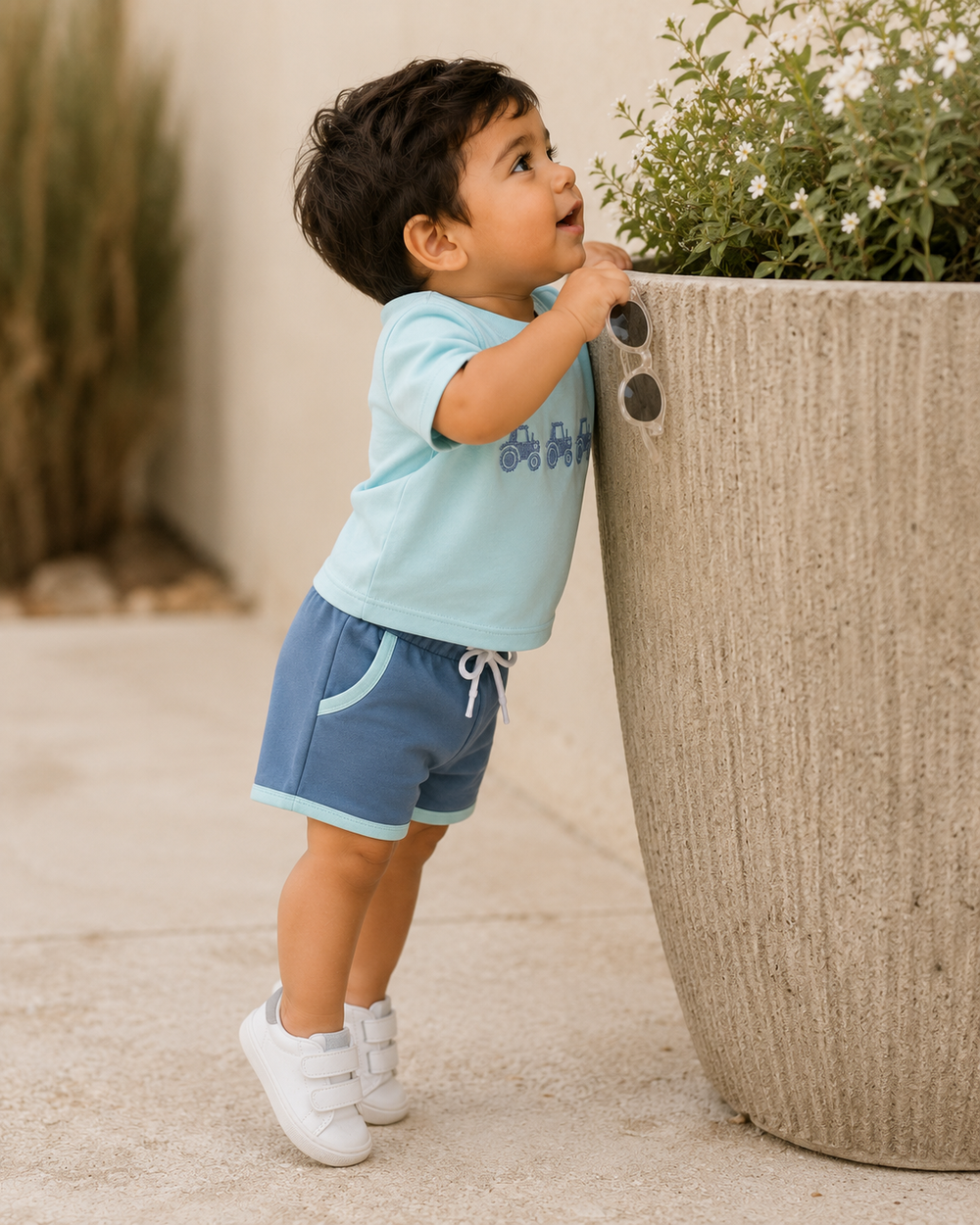 Boy is trying to look into a tall flower pot