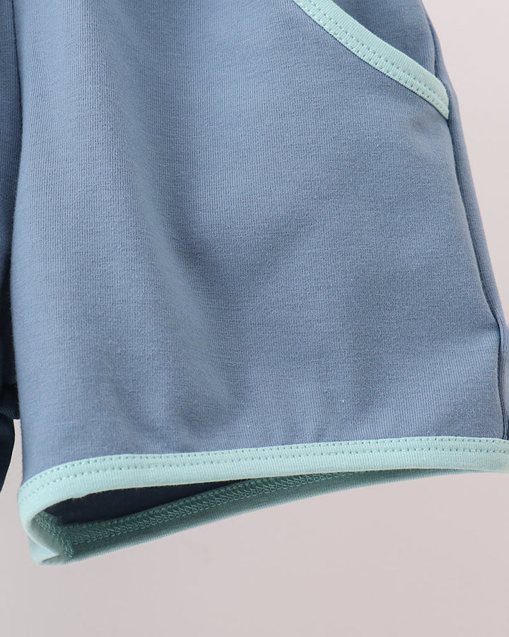 Close-up of a light blue garment with pale mint green contrast trim along the edge.
