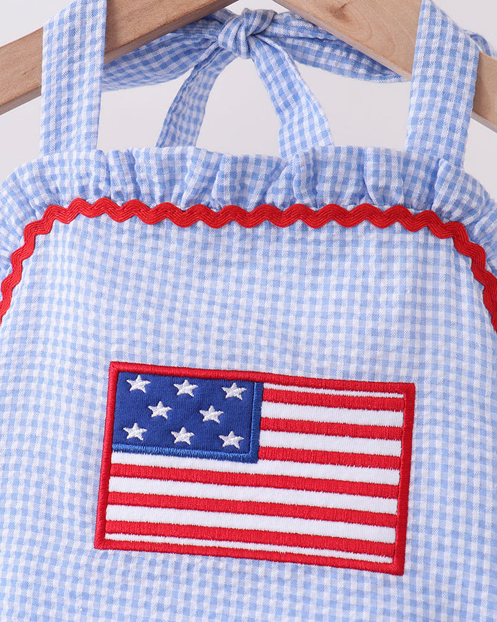 Blue checkered dress with American flag patch on a white background